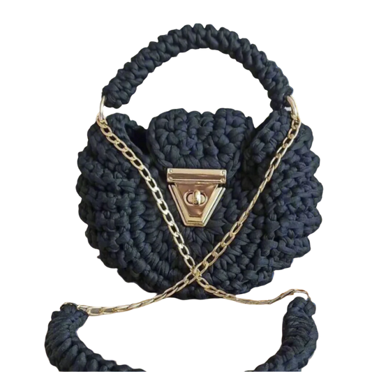 Black round crochet handbag with gold twist-lock clasp, side tassel, and optional gold chain – handcrafted for the Brunch at Tiffany’s Pebble Collection.
